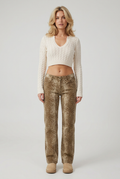 Blonde blow-out model wearing the cream cable-knit cropped jumper, deer-print jeans and beige boots