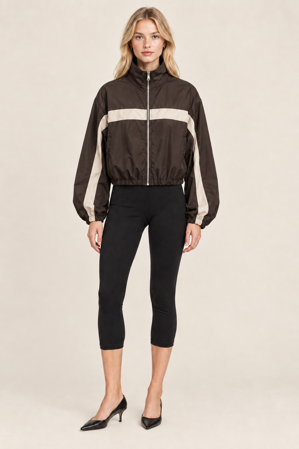 Blonde model in dark brown and stone striped track jacket, studio