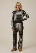 Blonde model wearing the black and cream striped fluffy knit jumper and matching trousers in a plain studio