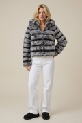 Blonde model wearing the grey banded faux fur hooded coat, white wide-leg jeans and black Uggs