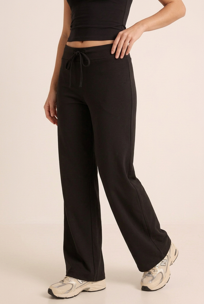 Close-up of the black wide-leg trousers in a new angled pose, showing the waistband, drawstring and fabric drape