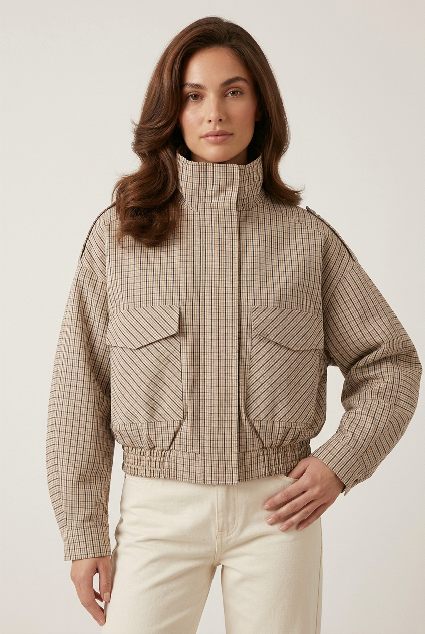 Front-facing close-up of the checked coat with a new hand-on-hip pose against a plain studio backdrop