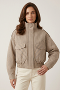 Front-facing close-up of the checked coat with a new hand-on-hip pose against a plain studio backdrop