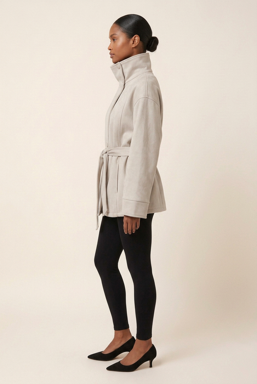 Full-length side profile of the suede jacket styled with black leggings and black kitten heels