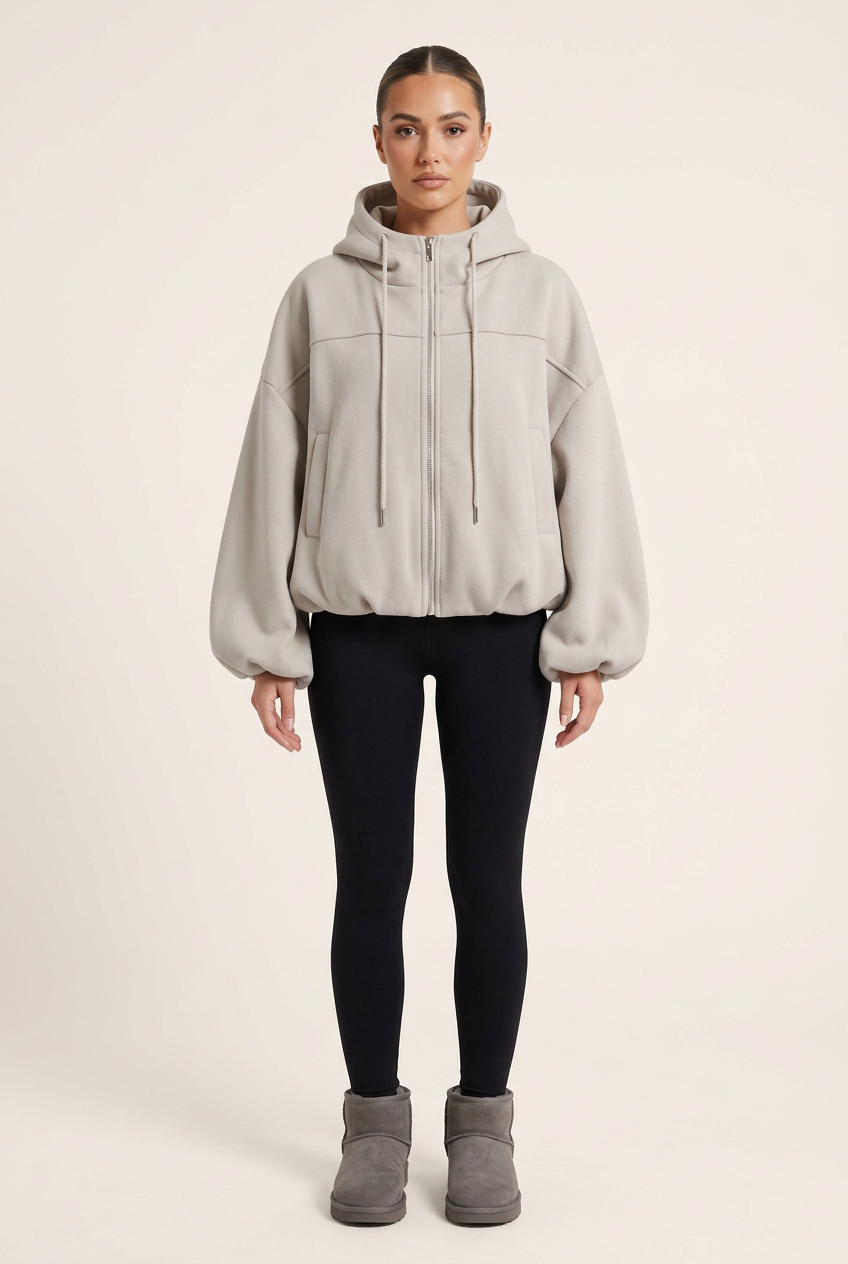 Plain studio image of the jersey jacket with black leggings, grey Ugg-style boots and a sleek brunette bun
