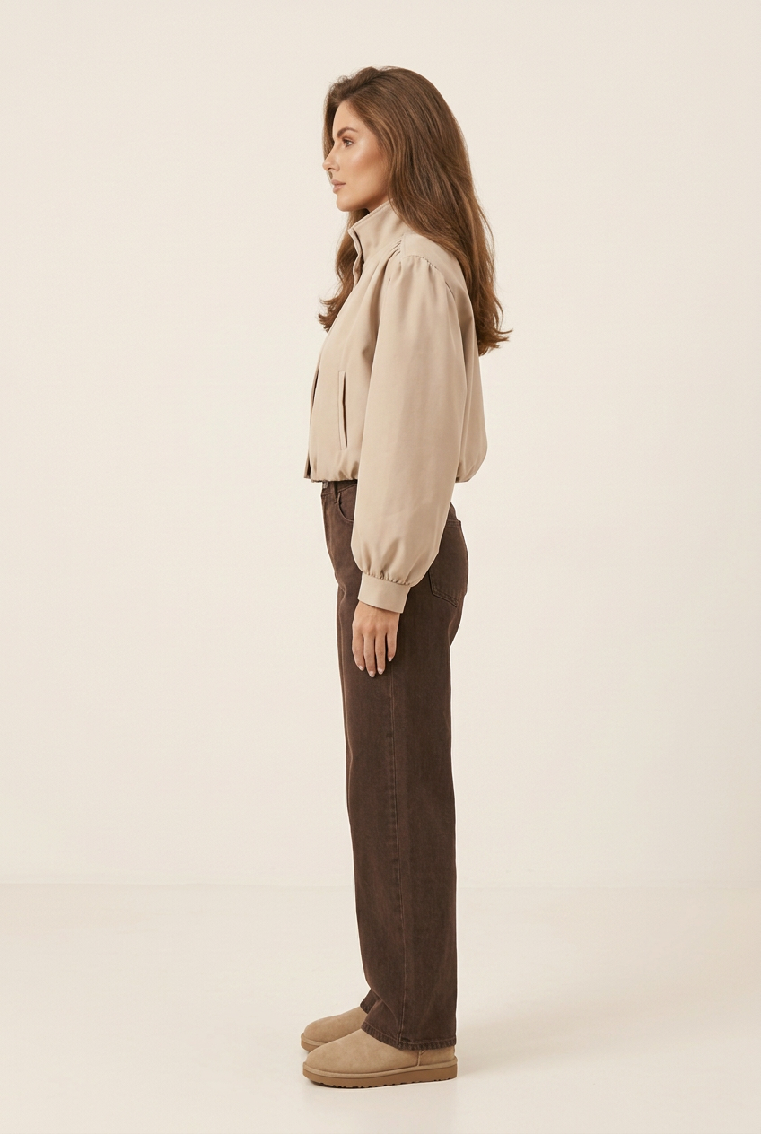 Side profile of the brunette model wearing the matte tailored jacket, dark brown wide-leg jeans and beige Ugg-style boots