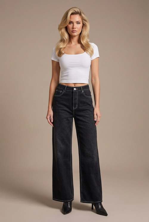 Studio image of blonde model in black contrast-stitch wide-leg jeans, white fitted tee, and black leather boots